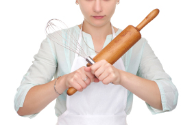 Chef holding whisk and rolling pin